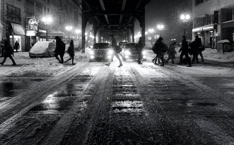 People walking on a city street in the winter at night.