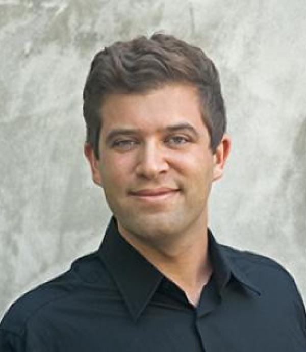 a person in a black collared shirt looking at the camera