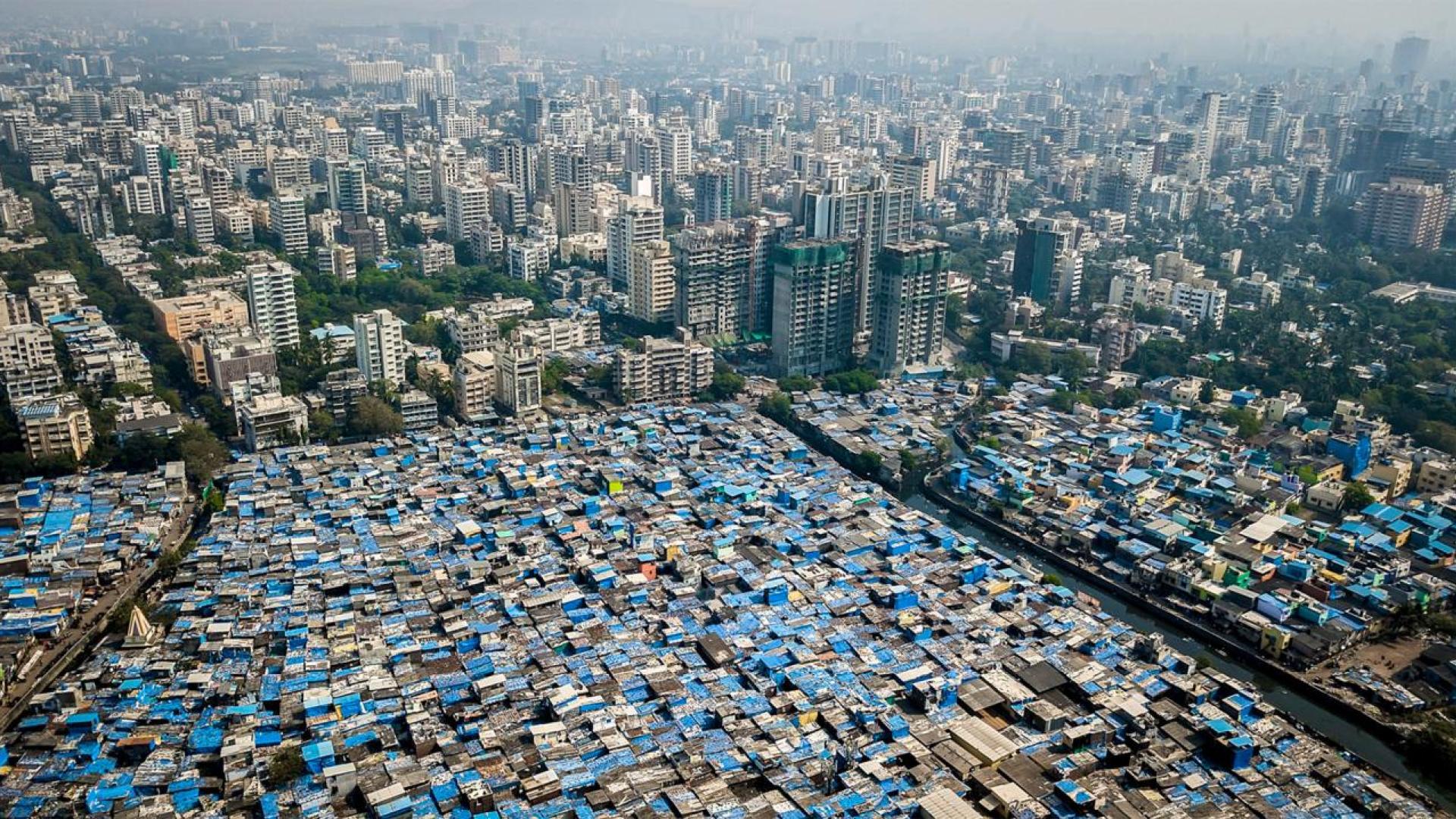 Aerial view of low-income housing against a backdrop of skyscrapers