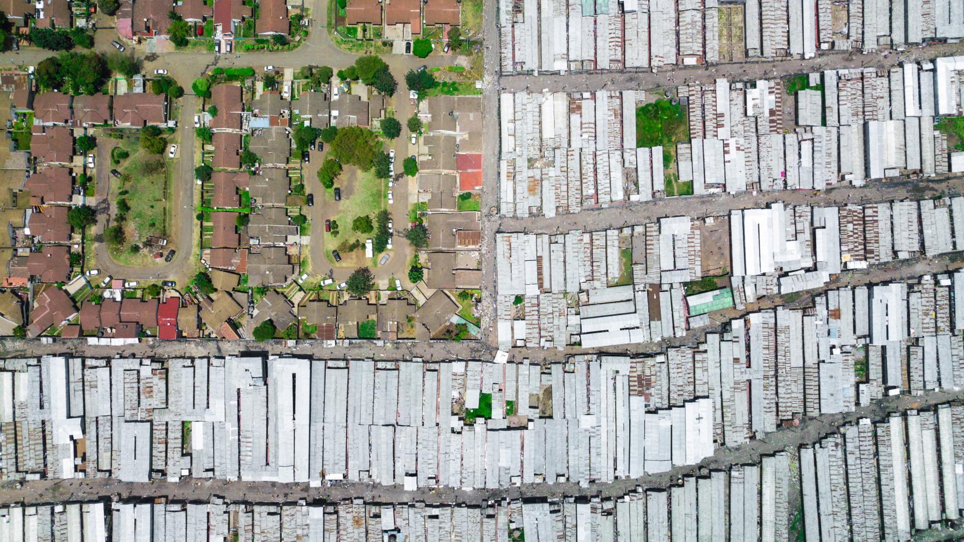 Aerial view spacious and green housing development surrouned by clustered low-income housing